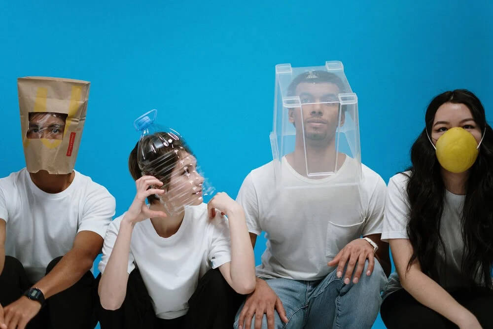 Four people wearing improvised protective face coverings