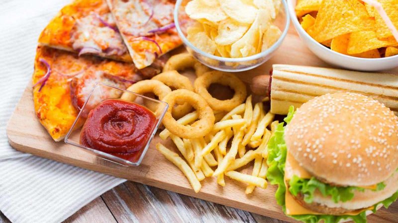 Fast food platter with burger, pizza, fries, and snacks