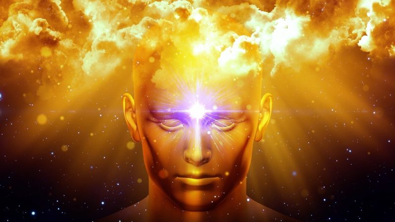 Golden figure with glowing third eye beneath luminous clouds