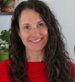 Smiling woman with long curly dark hair in red top